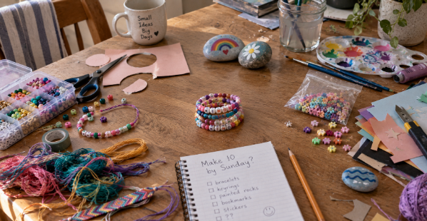 Several unfinished craft projects on a table with one finished set separated from the rest